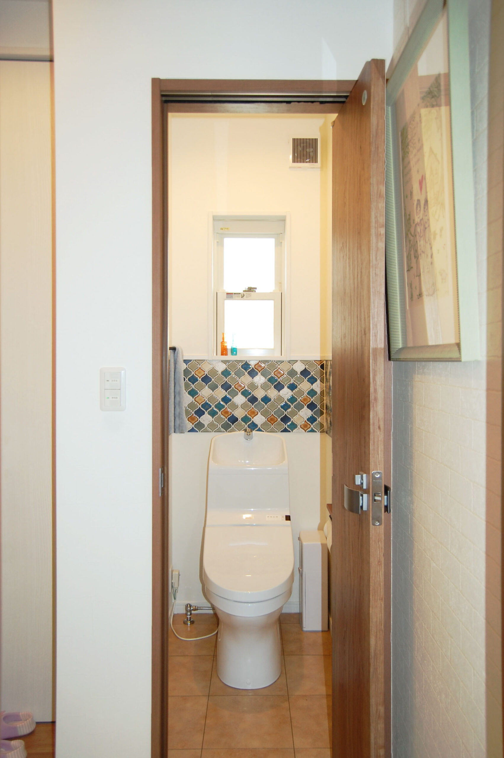 トイレにもモザイクタイルを使用。かわいい雰囲気に仕上がるだけでなく、水撥ね対策にもなる。