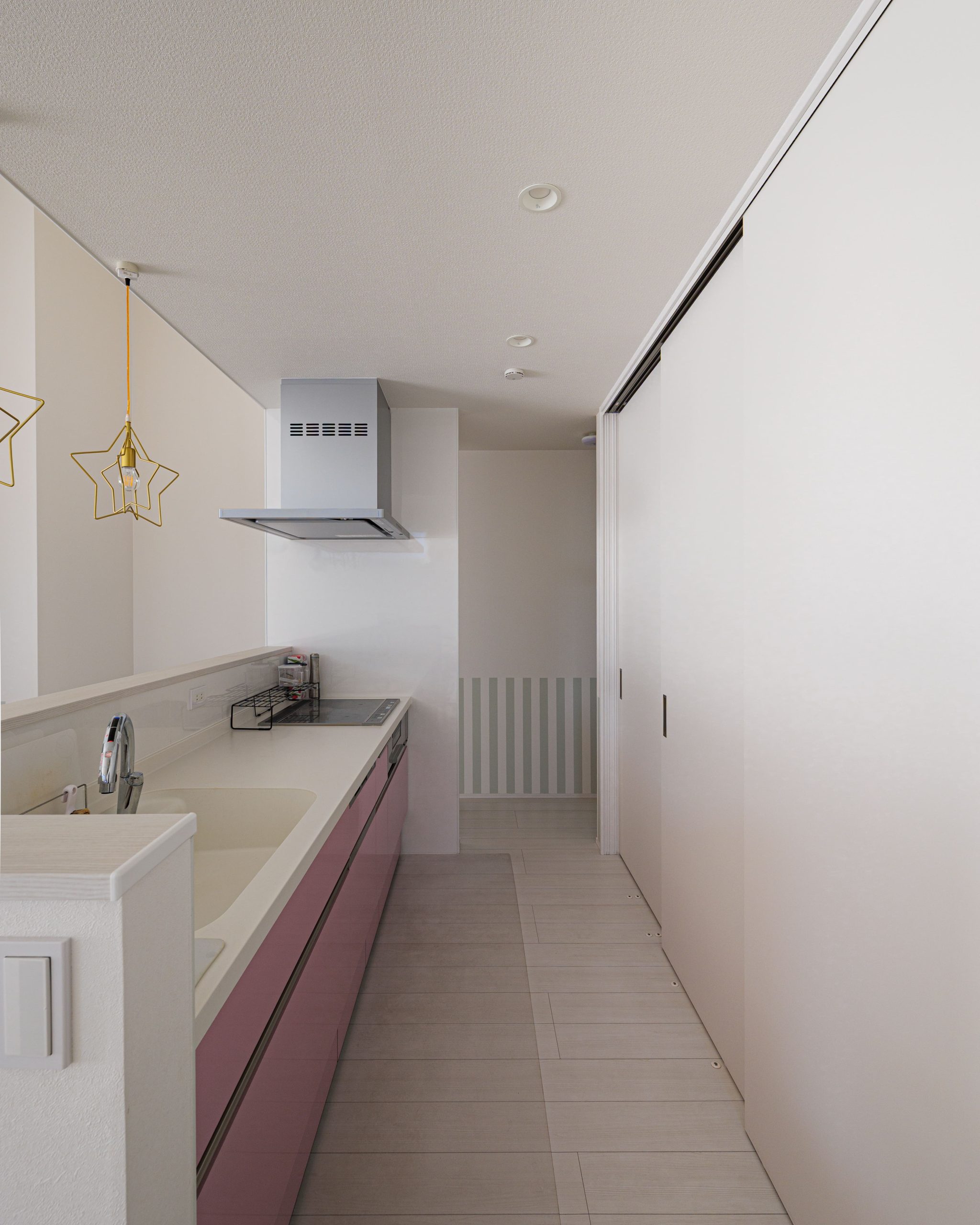 キッチン背面には冷蔵庫、食器棚などを隠すことができる収納が。生活感が出にくくスッキリとした印象を与える。