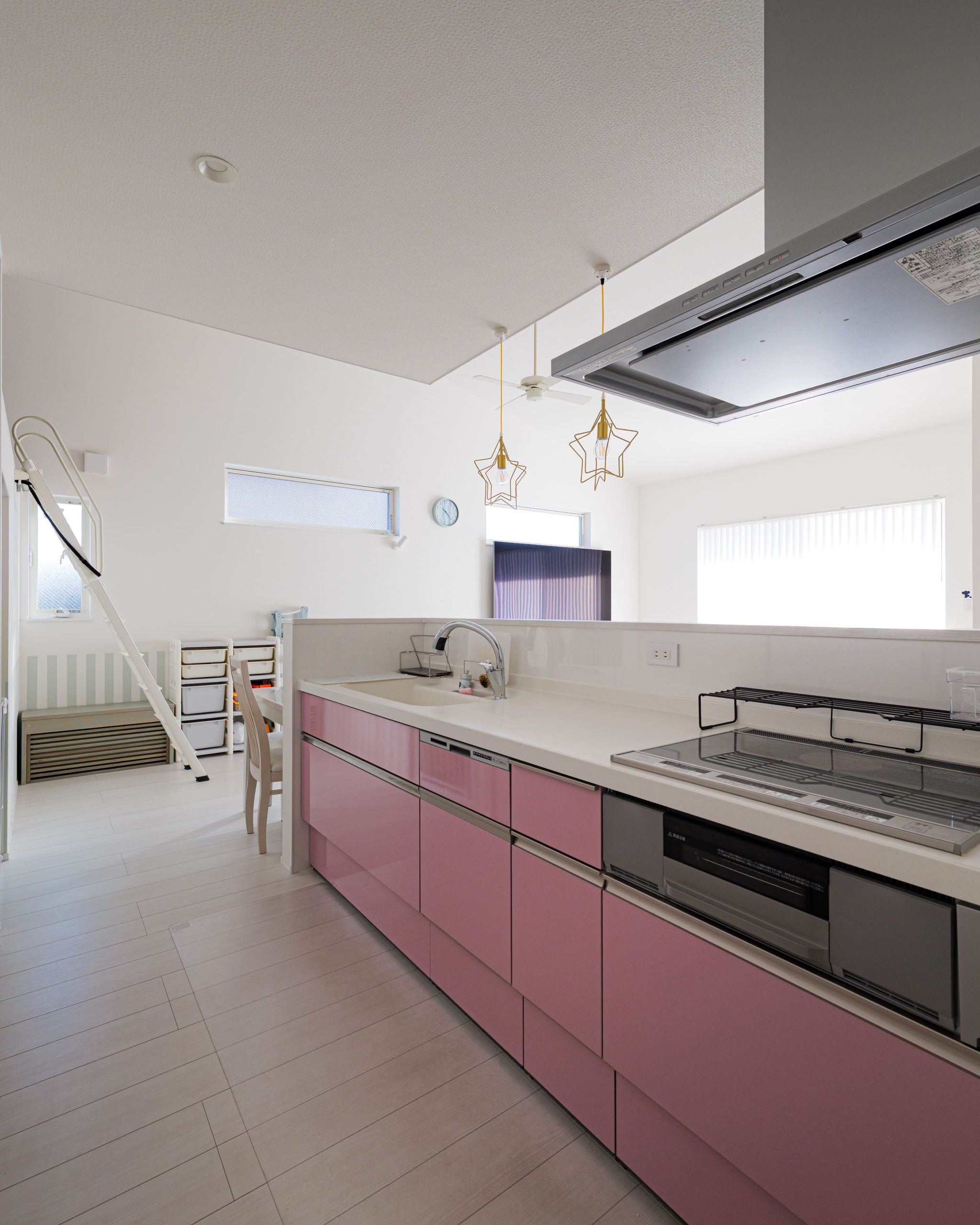 キッチン前は少し壁を立ち上げ、手元を隠すことでリビング側からは見えないよう工夫を。